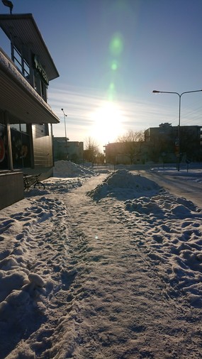 Snowy picture of a sidewalk in the sun